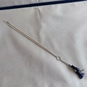 Gold colored necklace with black tassels